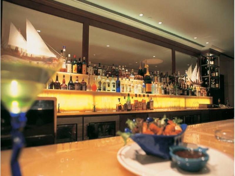 Hotel The Taj Mahal Tower, Bombay Esterno foto The photo depicts a stylish bar setting. In the background, there is a well-stocked bar shelf lined with numerous bottles of various alcoholic beverages, illuminated by soft lighting that creates a warm ambiance. The countertop appears to be smooth a