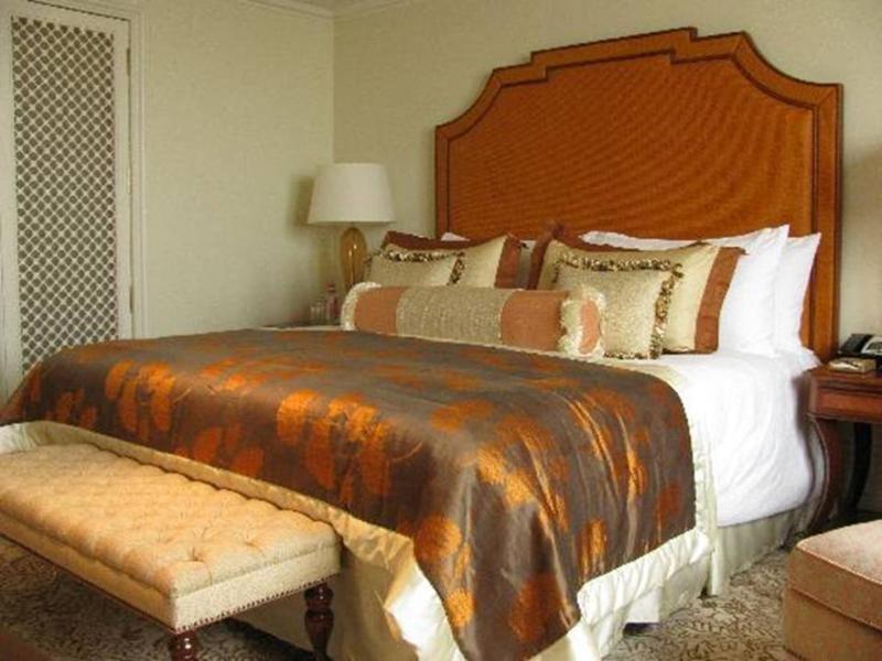 Hotel The Taj Mahal Tower, Bombay Esterno foto The photo shows a well-decorated bedroom featuring a large bed with an ornate headboard. The bed is dressed with a luxurious comforter that has a blend of rich colors, including brown and gold accents, along with multiple decorative pillows. At the f