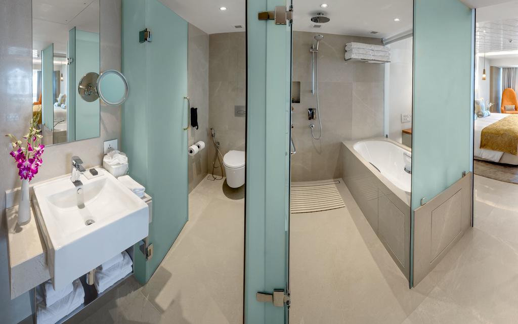 Hotel The Taj Mahal Tower, Bombay Esterno foto The photo shows a modern bathroom with a sleek design. To the left, there is a sink with a mirror above it, and beneath the sink, there are some storage shelves. The area also features a glass partition leading to a shower. On the right side, there i
